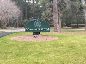 A green sign for Shipyard Golf Club with a ship logo, surrounded by grass and trees. - Shipmaster - Spacious 3BR, 3 Bath with Golf-View/Tennis/Pool/BEACH LOCKER (Hilton Head Island)