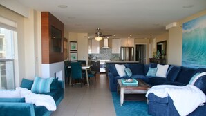 Una sala de estar moderna con un conjunto de sofá, una mesa de centro y un comedor al fondo.
