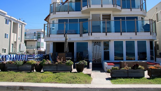 Un edificio residencial de varios pisos con balcones, ventanas amplias y zonas de estar al aire libre.