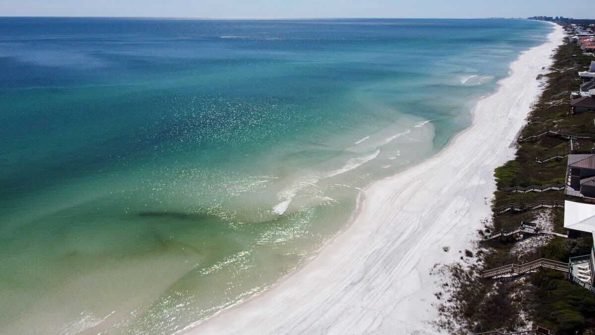 A coastal view with a sandy beach and a clear blue ocean.