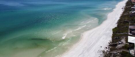 A coastal view with a sandy beach and a clear blue ocean.