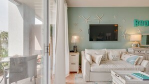 A room with a white sofa, a television on the wall, and starfish decorations. - 500 Ft from Beach! 3 Pools (1 Seasonally Heated)! Ground Floor Condo! ~ Cabana 103 at Gulf Place on 30A (Santa Rosa Beach)