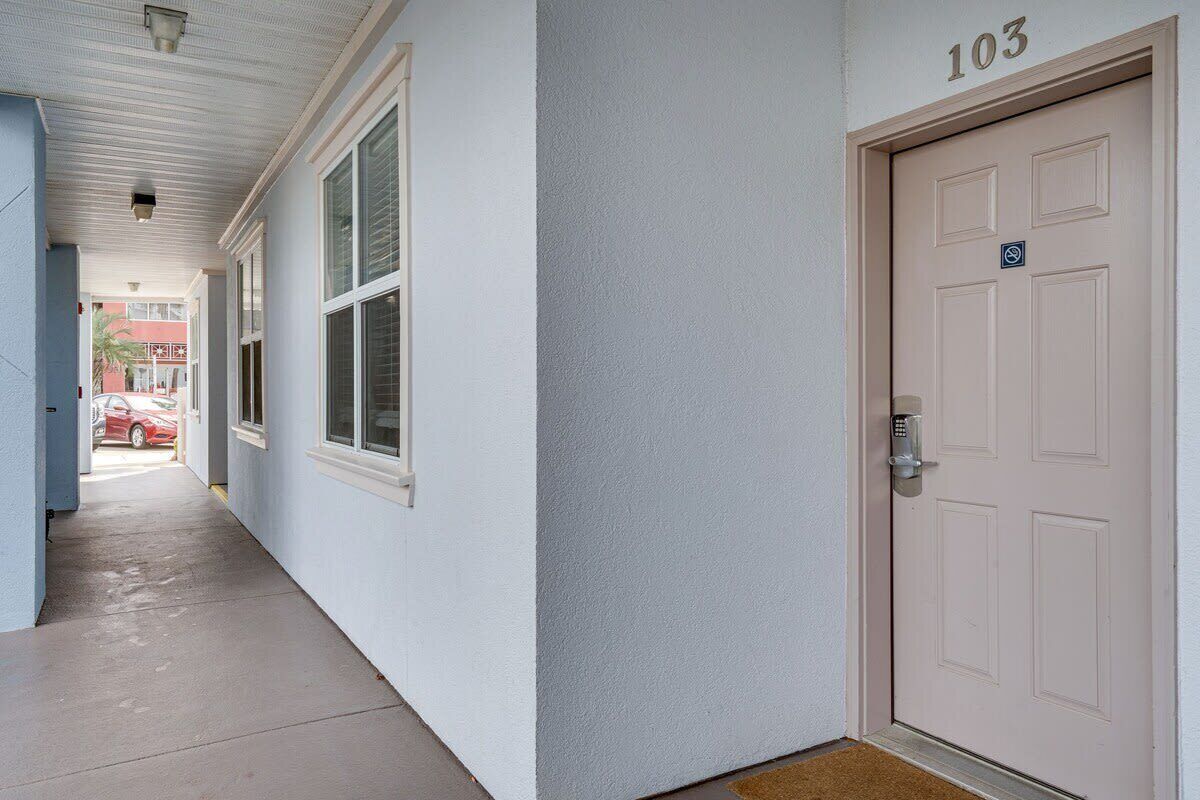A hallway with a door marked '103' and a doormat.