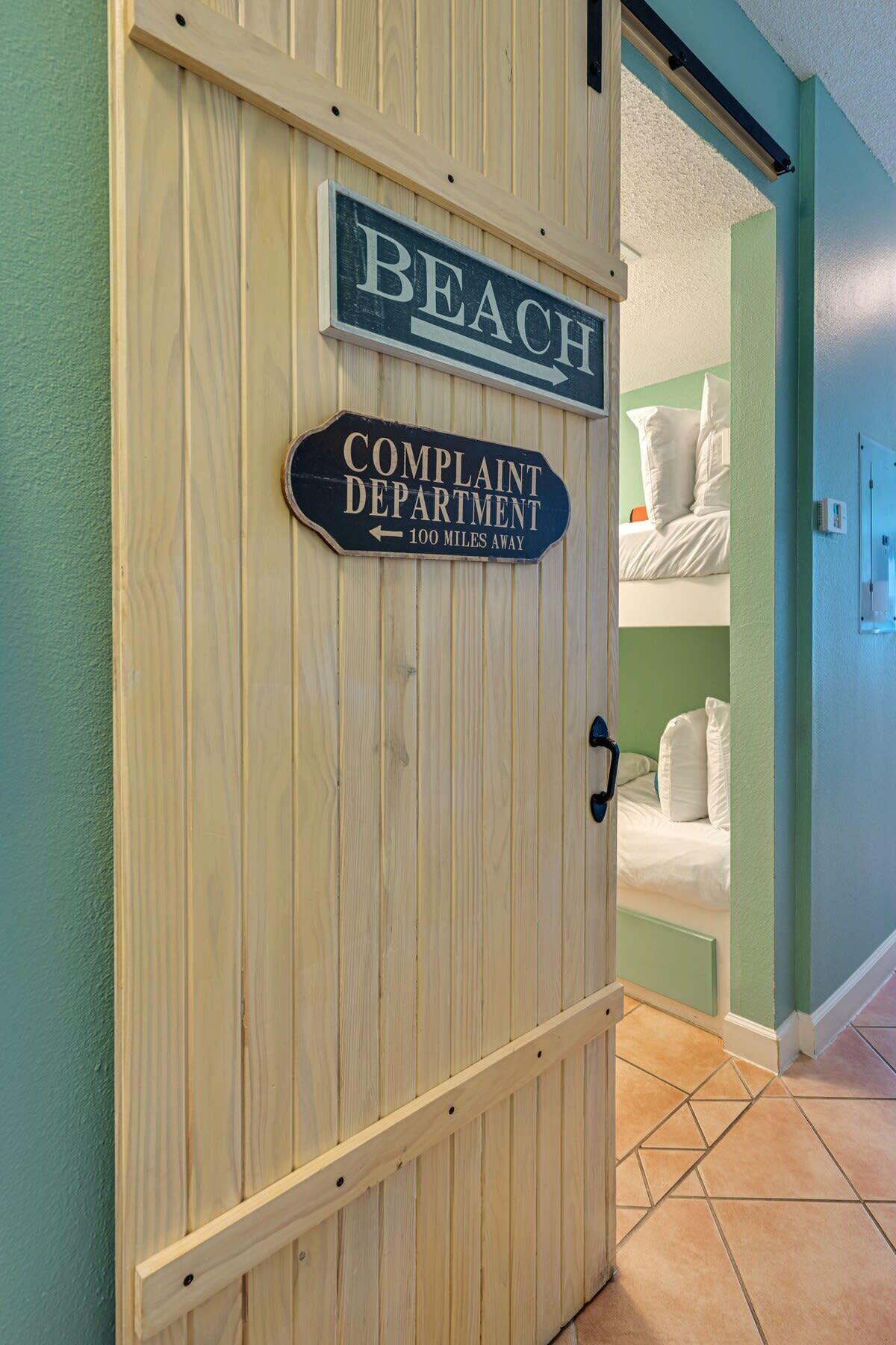 A wooden door with a sign indicating the direction to the Complaint Department.