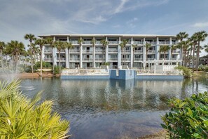 Un hôtel à plusieurs étages doté de balcons, d’une piscine et de palmiers.