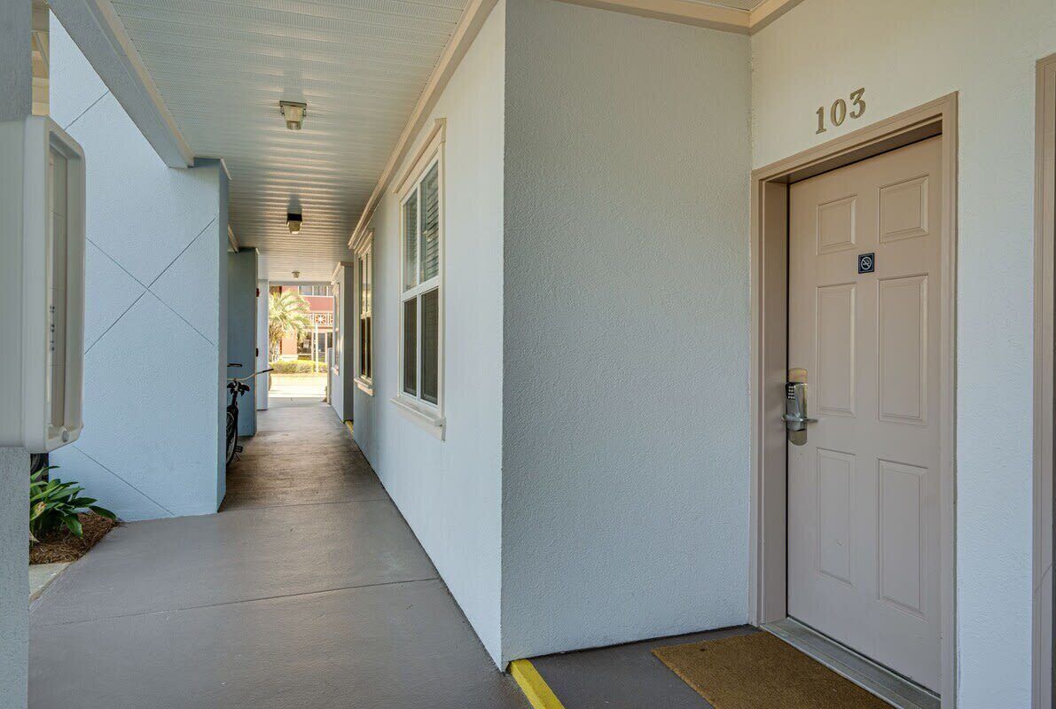 A corridor with a door marked '103' and a bicycle parked outside.