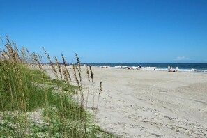 Enjoy a serene beach experience with expansive views of the calm sea.