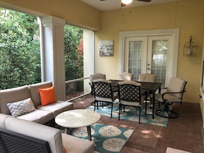 A covered patio with a sofa, round table, and dining set. - Golf Cart & 4 Bikes! Walk to the Beach & the Pool! One Story Home in Gated Comm! ~ Our Little Peace of Paradise at Destiny West (Destin)