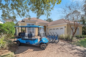 A golf cart parked in front of a house with a garage and bicycles. - Golf Cart & 4 Bikes! Walk to the Beach & the Pool! One Story Home in Gated Comm! ~ Our Little Peace of Paradise at Destiny West (Destin)