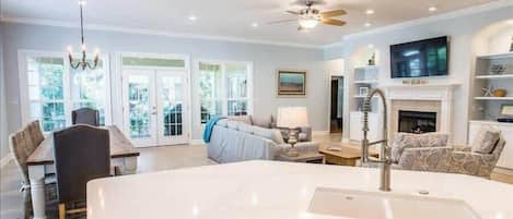 A spacious living area with a large island, a fireplace, and a television.