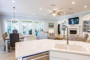 A spacious living area with a large island, a fireplace, and a television. - Golf Cart & 4 Bikes! Walk to the Beach & the Pool! One Story Home in Gated Comm! ~ Our Little Peace of Paradise at Destiny West (Destin)