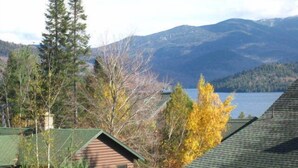 A cabin with a view of a lake and mountains.