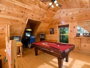 Enjoy a game of pool in this room with a pool table and a window offering a view of the outdoors.