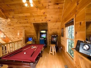 Enjoy a game of pool or challenge friends at the pool table in this room, which also features arcade games and a window with a view.