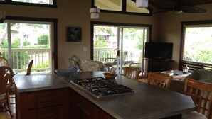 A kitchen with a large island, wooden cabinets, and a dining area with chairs. - Magical 4 Bedroom 3 Bath Home with Awesome Mountain View's. New Full house AC (Princeville)