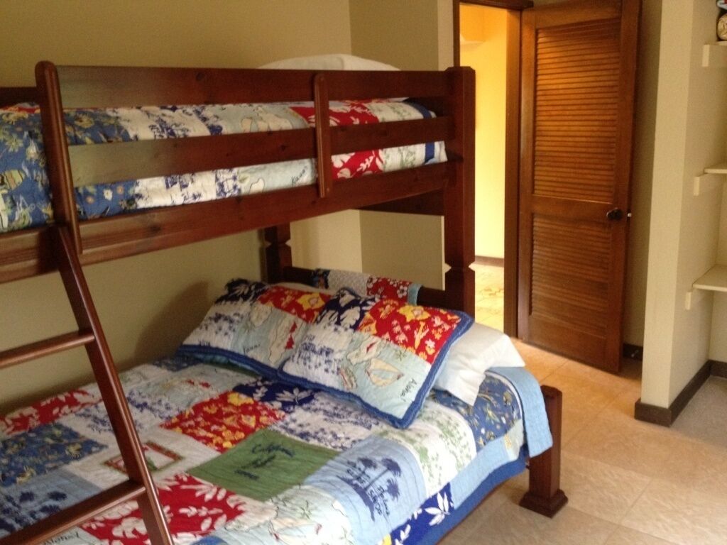 Een stapelbed met bloemenbeddengoed en een houten trap.