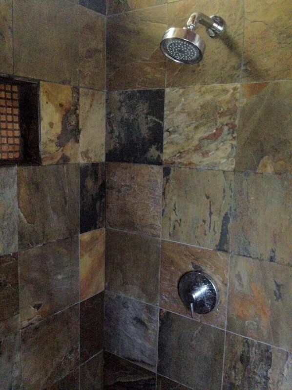 Ein Duschbereich mit Regendusche und Ablauf.