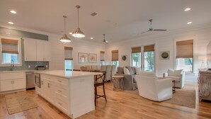 A spacious living area with a central island, a dining table, and a seating arrangement.