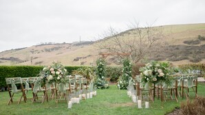 An outdoor wedding setup with rows of chairs and floral decorations. - Tottington Manor (Henfield)