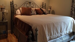 A neatly made bed with a headboard, two bedside tables with lamps, and a floral-patterned curtain. - Snowcreek Condo at Sugarbush Resort-2 beds/2 baths, slopeside (Warren)
