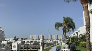 Un port de plaisance avec des bateaux amarrés, un sentier et des espaces de repos en plein air.