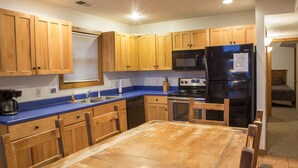 A kitchen with wooden cabinets, a black refrigerator, a microwave, and a blue countertop. - Perfect family space. Lots of room. Easy drive to New River Gorge National Park. (Ghent)