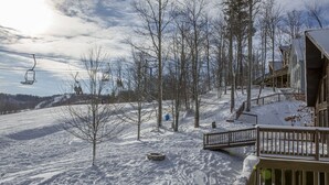 A snow-covered landscape with a ski lift, wooden buildings, and a wooden deck. - Perfect family space. Lots of room. Easy drive to New River Gorge National Park. (Ghent)
