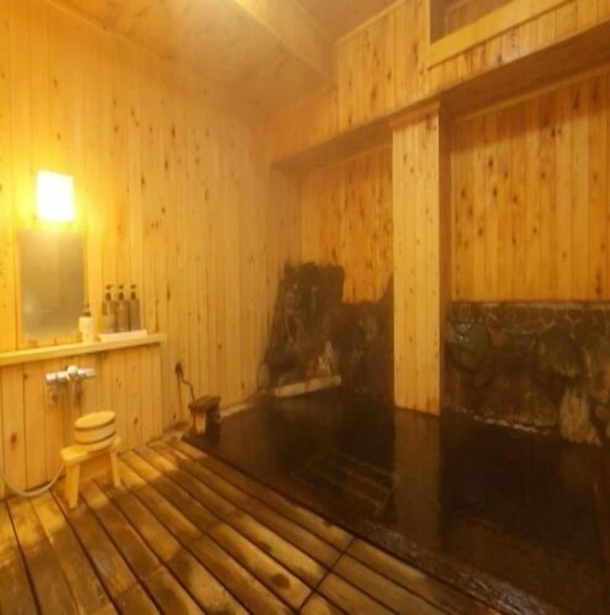A wooden interior with a sauna, a toilet, and a mirror.