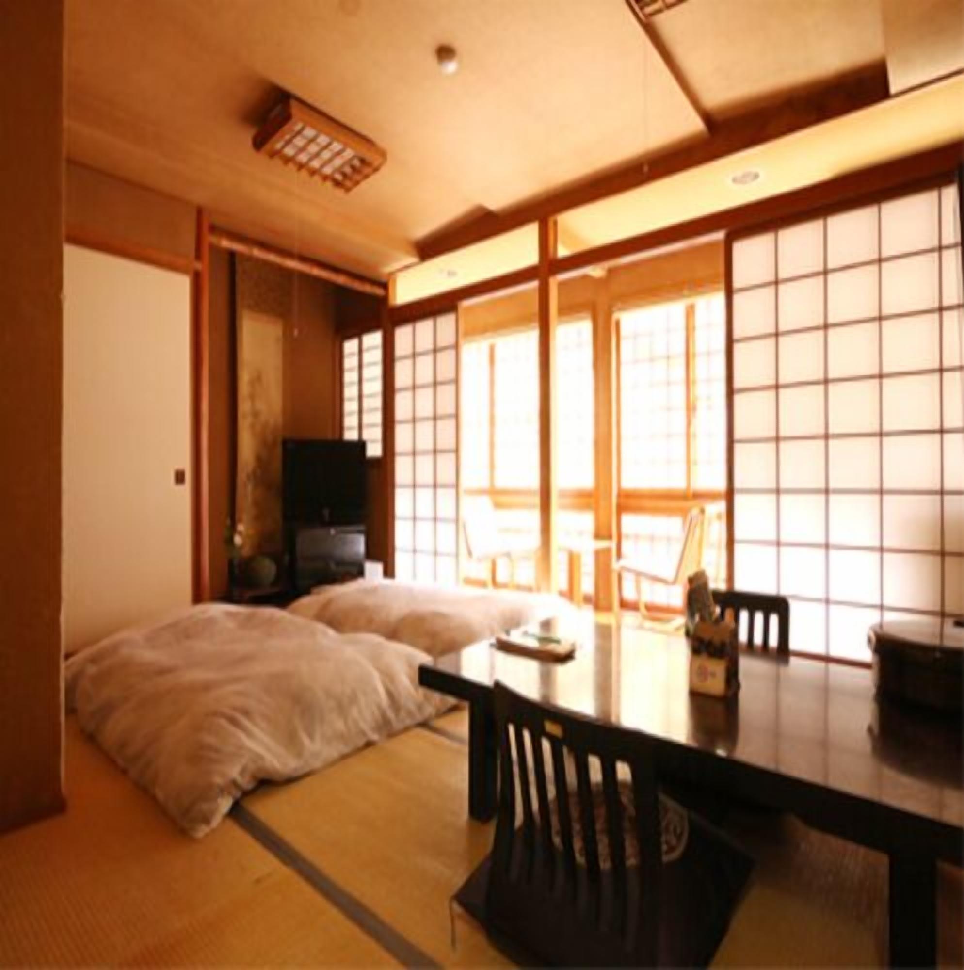 A traditional Japanese room with tatami flooring, a low table, and sliding doors.