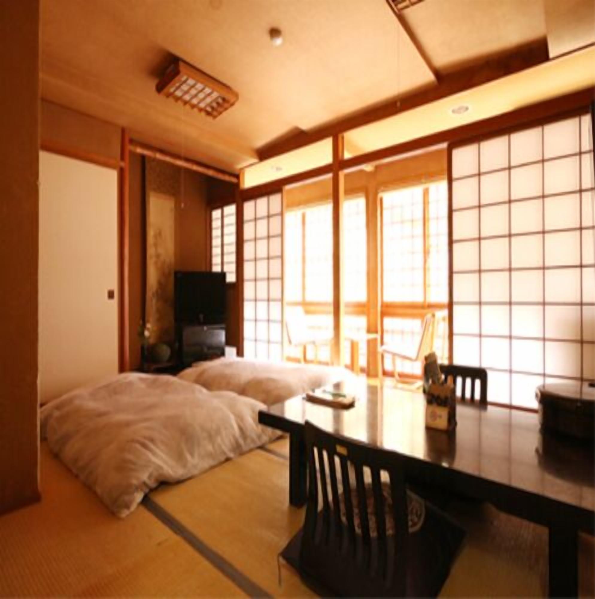 A traditional Japanese room with tatami flooring, a low table, and sliding doors.