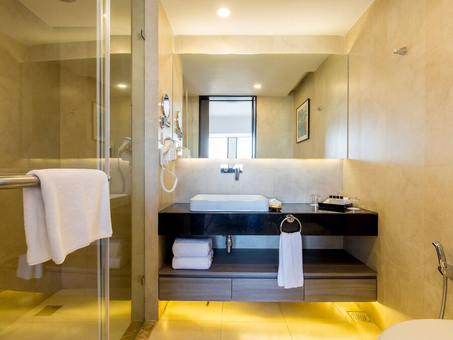 A modern bathroom with a glass-enclosed shower, a large sink, and a toilet.