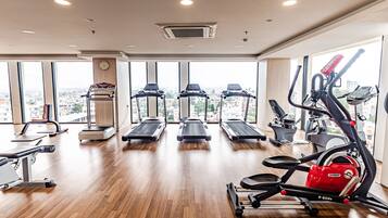 Un gimnasio con cintas de correr, elípticas y equipos de pesas.