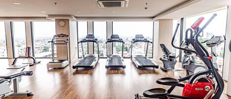 A gym with treadmills, elliptical machines, and weight equipment.