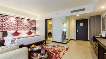 A hotel room with a large bed, bedside tables, a desk, and a chair.