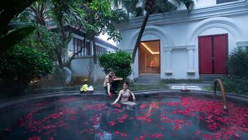 Relax by the serene pool surrounded by lush greenery and elegant architecture.
