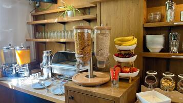 A breakfast buffet with various food options, including cereal, fruits, and beverages.