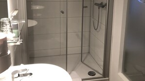 A modern bathroom with a glass-enclosed shower, a round sink, and a mirror. - Gasthaus Zum Schwan (Dillenburg)