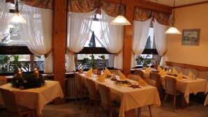 A restaurant with multiple tables set for dining, featuring white tablecloths and yellow napkins. - Blick zum Maimont (Ludwigswinkel)