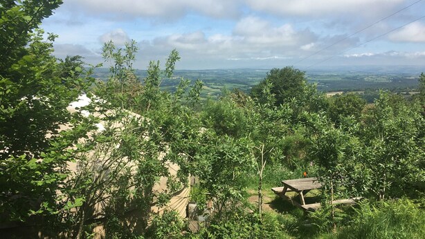 A view of a countryside landscape with a picnic table surrounded by greenery. - Yurt Luxury & Bathouse (Callington)