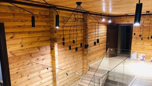 Un interior de fusta amb una escala de vidre i llums penjants.