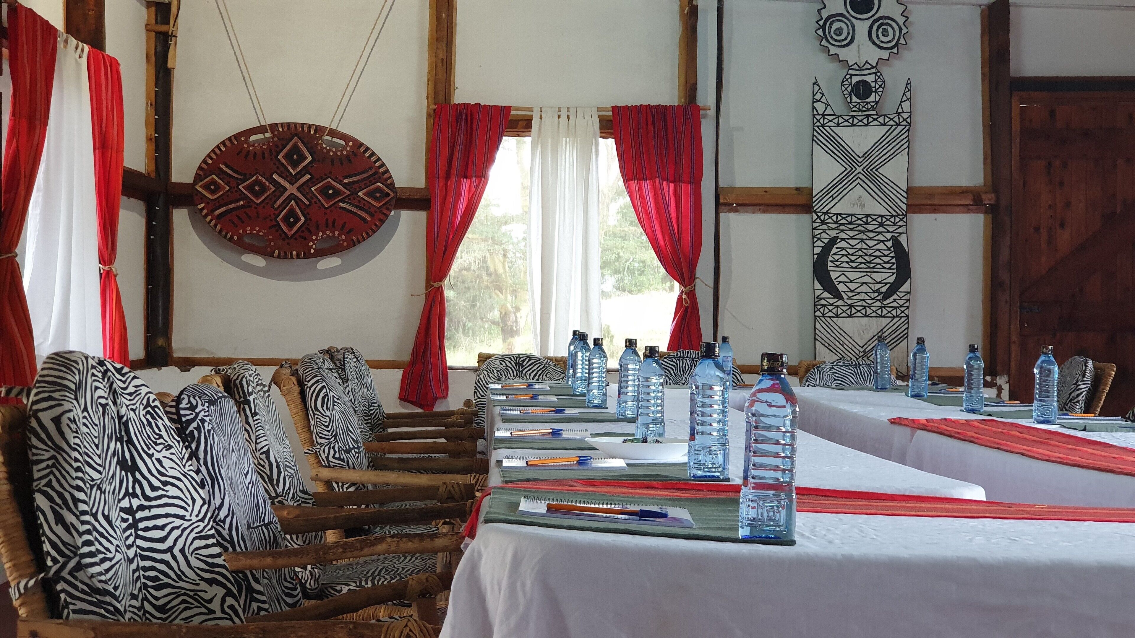 A long table with chairs, water bottles, and notebooks.