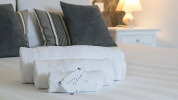 A neatly made bed with white towels and a tag reading "Residenza N Punto."