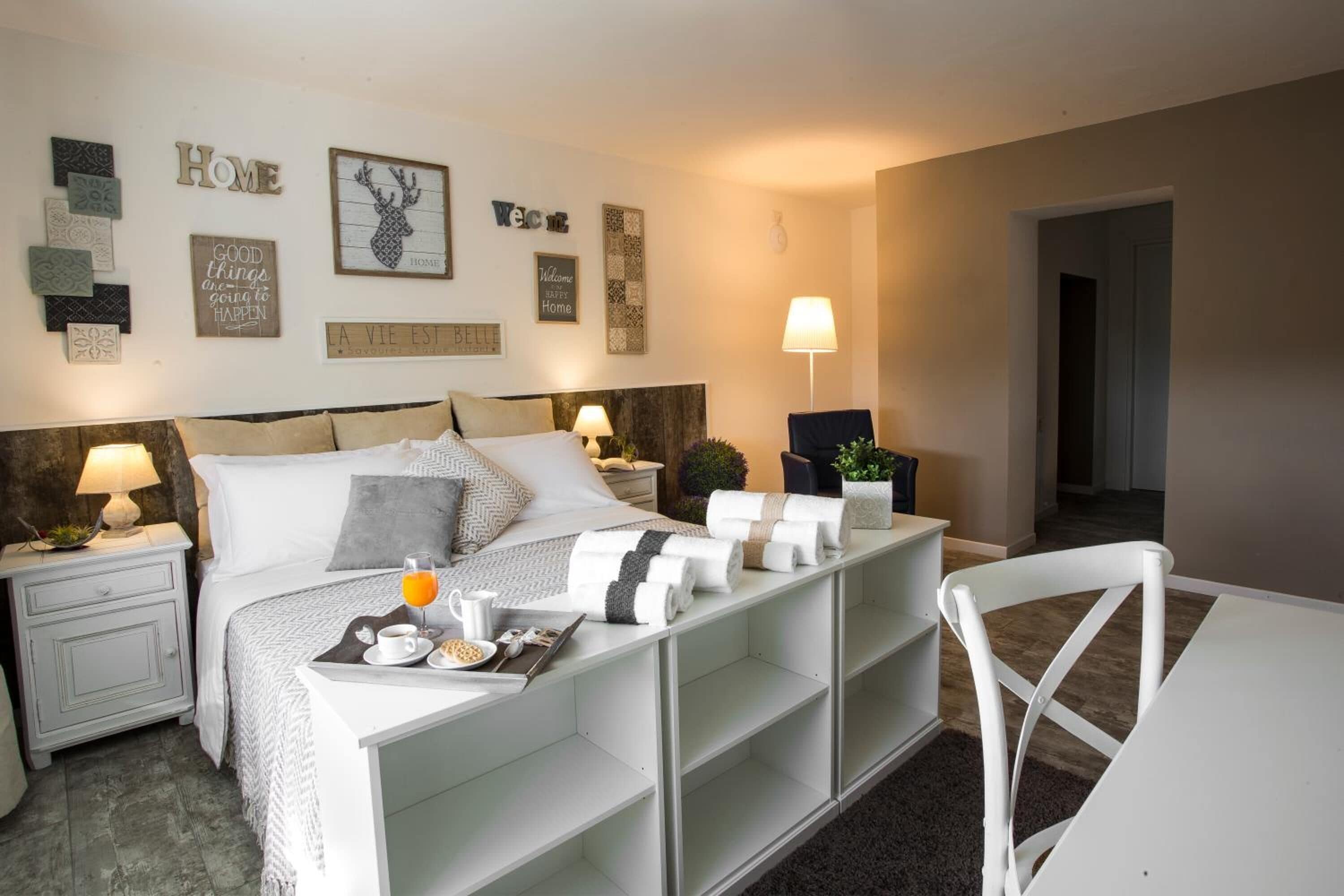 Une chambre bien rangée, avec un lit, des tables de chevet, un bureau et une chaise.