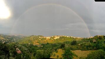 Paisagem com um arco-íris sobre uma cidade.