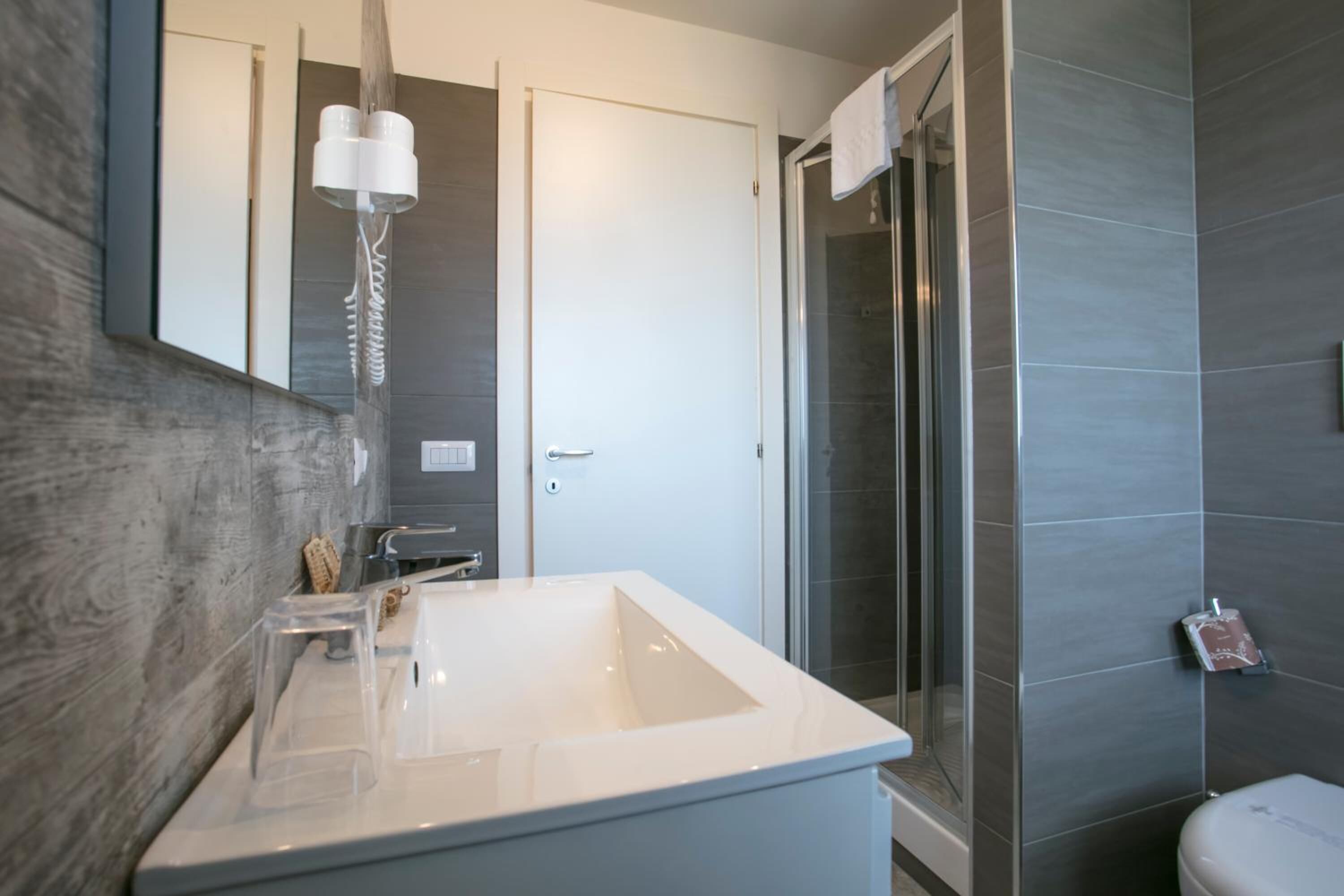 Un baño moderno con un lavamanos grande, una cabina de ducha de vidrio y un inodoro.