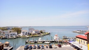 A marina with boats docked, a pier, and buildings along the waterfront. - Stylish, upscale luxury 4-bedroom condo with free WiFi and an outdoor pool located downtown on the bay water and just a few blocks to the beach! (Ocean City)