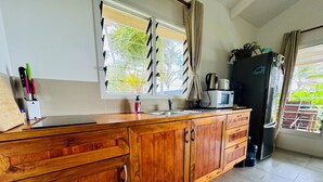 Une cuisine avec des meubles de rangement en bois, un évier, un four à micro-ondes et un réfrigérateur.