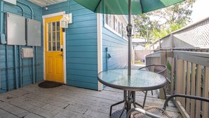A blue house with a yellow door, a glass table, and a green umbrella. - 1 bedroom Apartment in quaint triplex 12 blocks from UF and downtown (Gainesville)