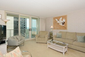 A living room with a sofa, armchair, and a glass coffee table. - XPLORIE ACTIVITIES & LINENS INCLUDED*! QUAY 2 BR/2 BA Ocean View Condo with Indoor/Outdoor Pools. (Ocean City)