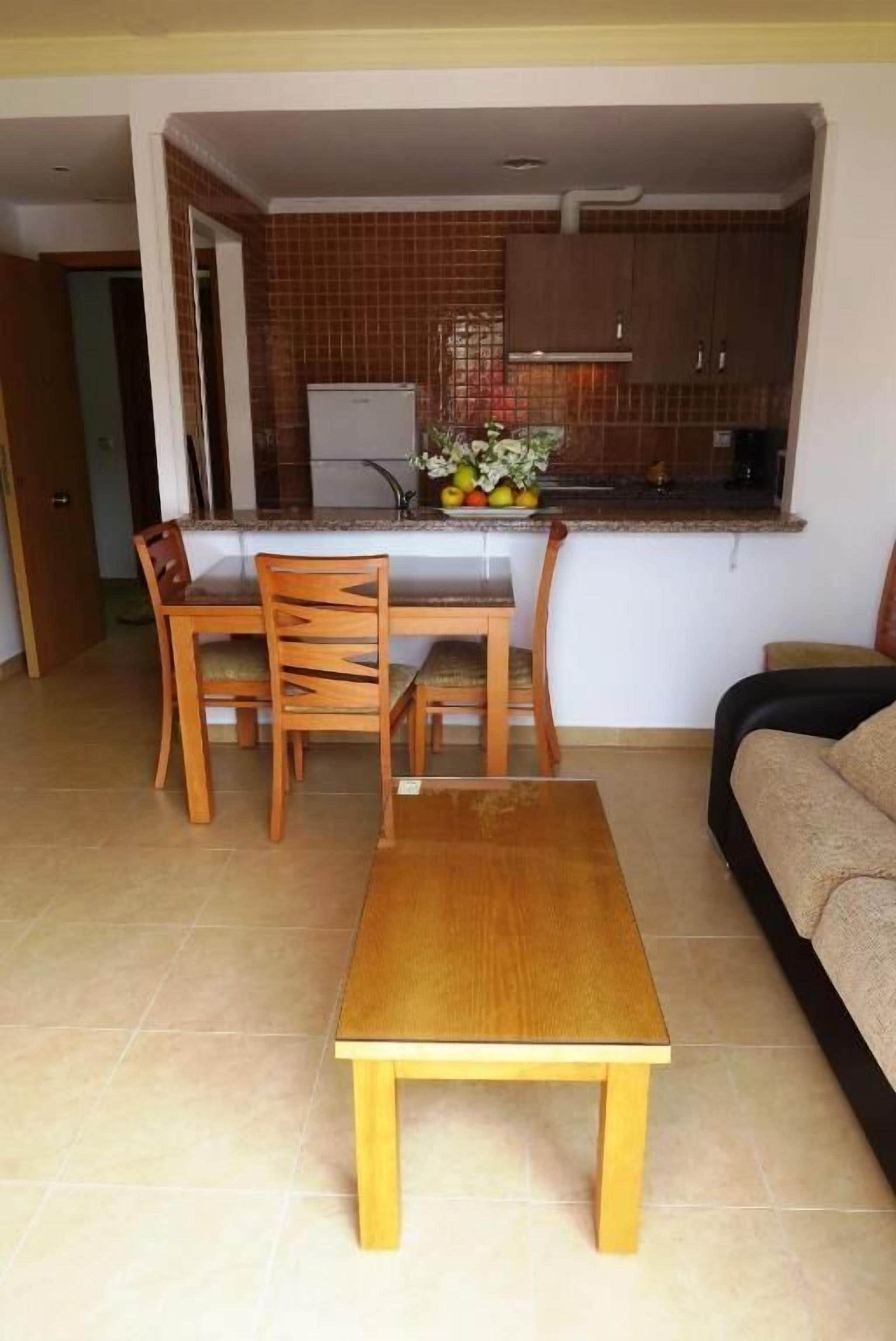 Un espacio habitable compacto con comedor, kitchenette y sofá.